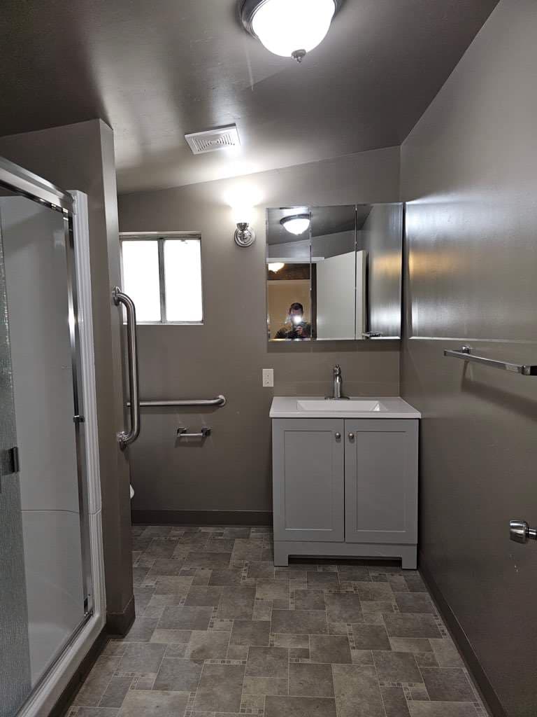 Finished accessible bathroom remodel — new gray vanity, tiled floor and walk-in shower — by RLS Custom Carpentry in Mendocino County, CA