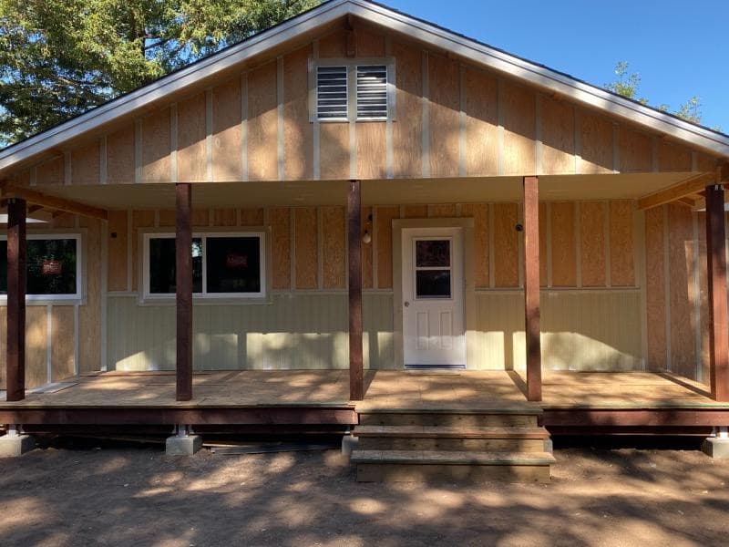 New board-and-batten siding and a covered porch with timber posts by RLS Custom Carpentry in Mendocino County, CA