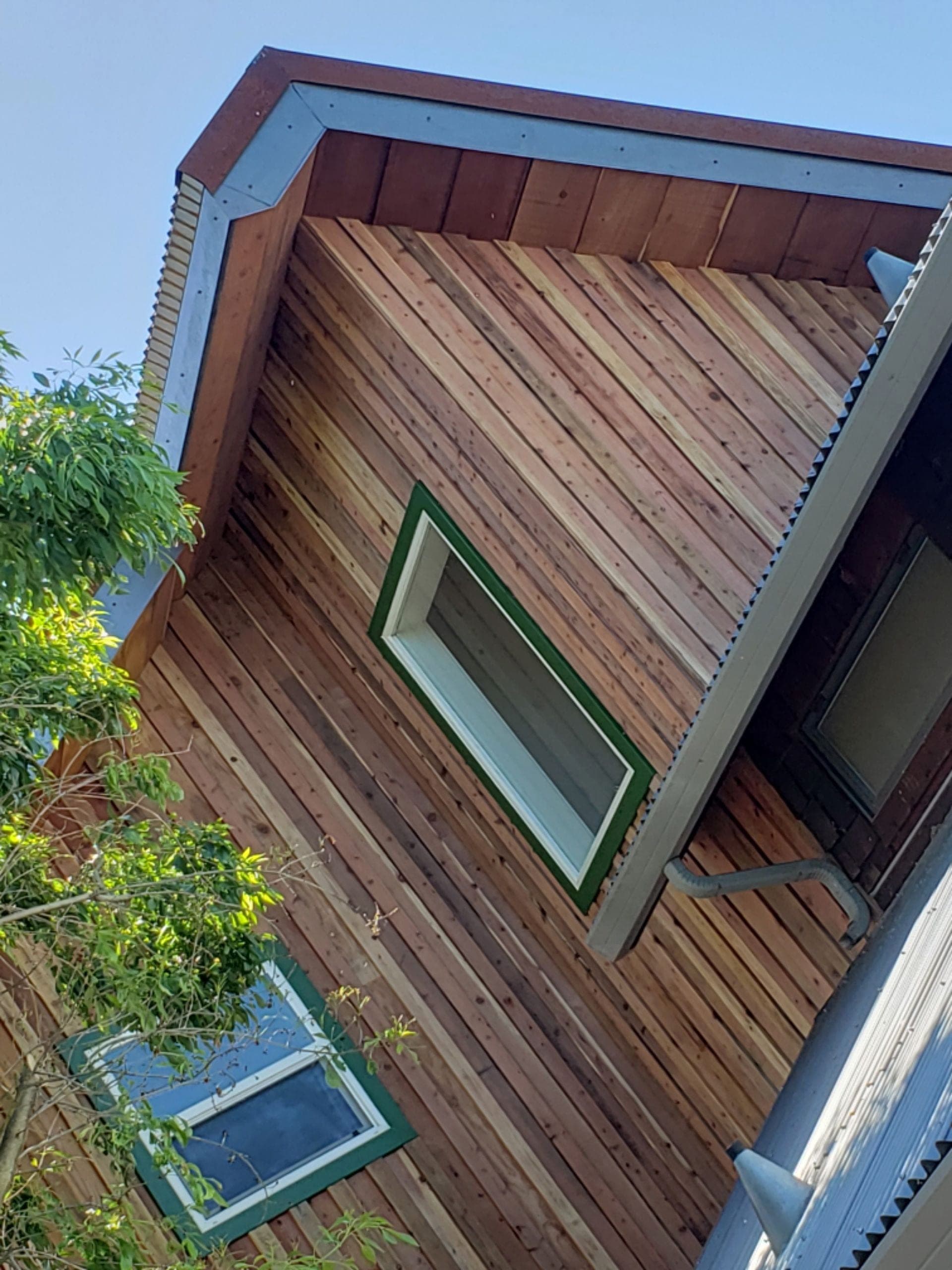 Upward view of custom cedar gable and siding against a deep blue sky, built by RLS Custom Carpentry in Mendocino County, CA
