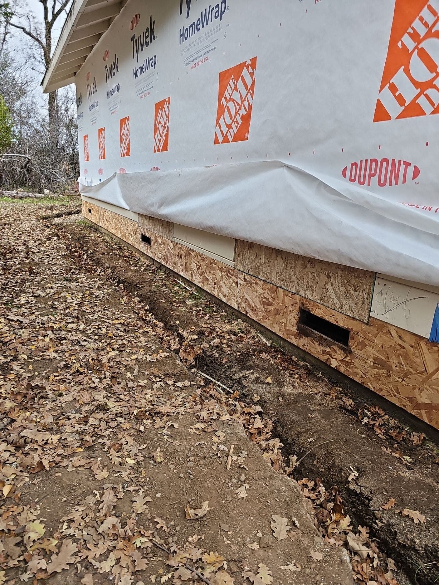 Completed new OSB rim sheathing and Tyvek HomeWrap along the repaired wall base at 5160 Burke Hill Rd, a sill and rim restoration by RLS Custom Carpentry in Mendocino County, CA
