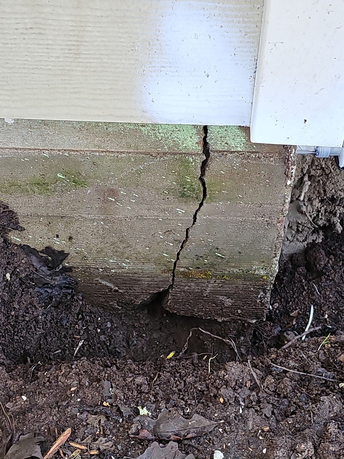 Vertical crack in a concrete foundation stem wall exposed by hand excavation before RLS Custom Carpentry foundation repair in Mendocino County, CA