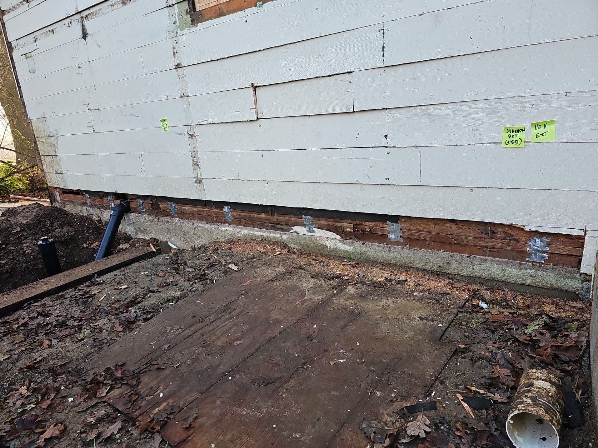 New concrete foundation with anchor bolts and seismic hold-down hardware installed under an exterior wall by RLS Custom Carpentry, a foundation retrofit in Mendocino County, CA
