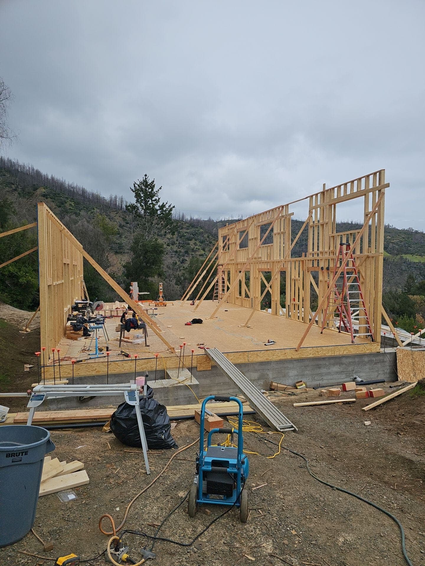 New home wood wall framing taking shape on a concrete foundation, built by RLS Custom Carpentry in Mendocino County, CA