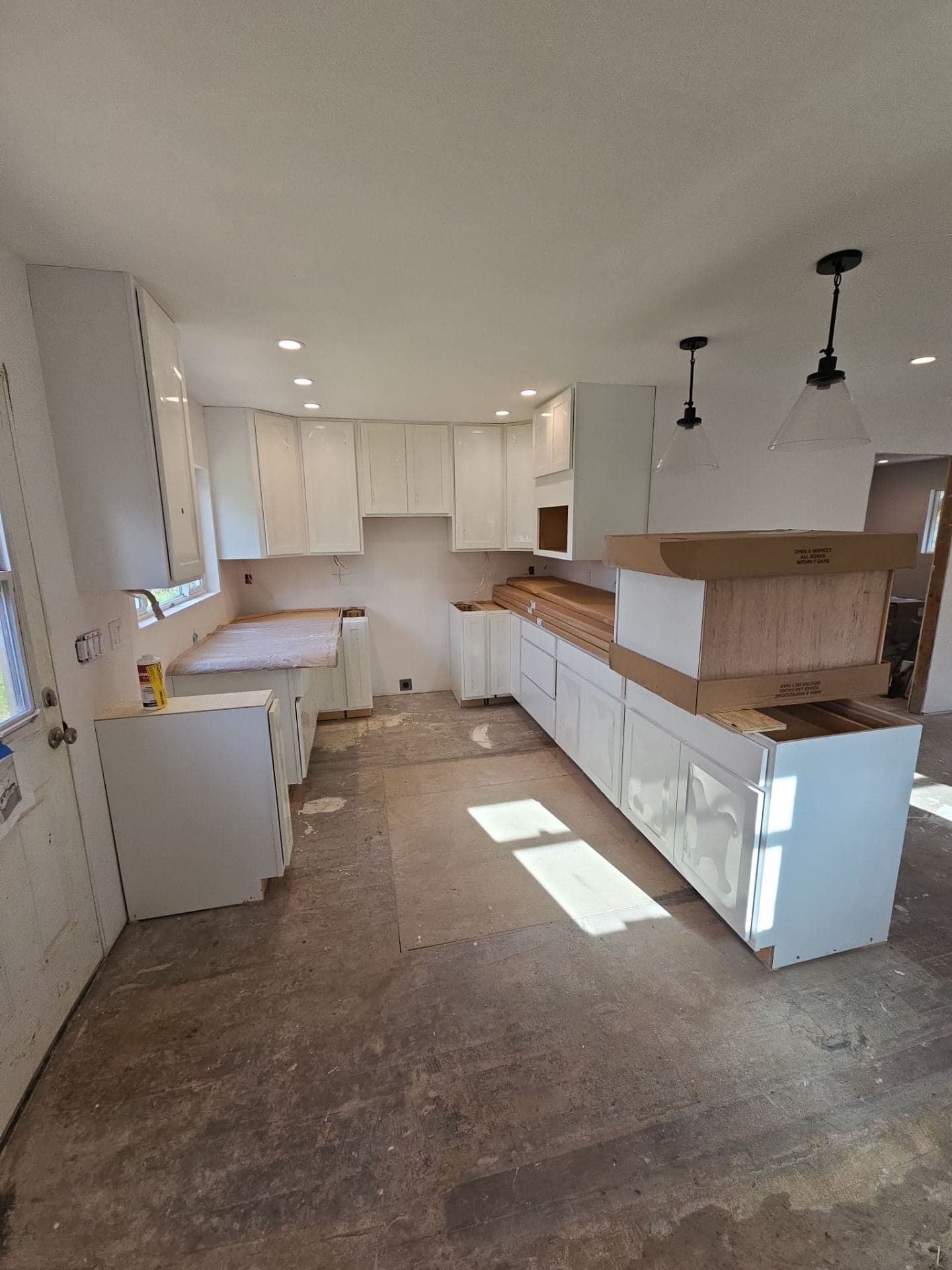 Kitchen remodel at 5160 Burke Hill Rd in Mendocino County with new white shaker cabinets, recessed lighting and pendant fixtures installed by RLS Custom Carpentry