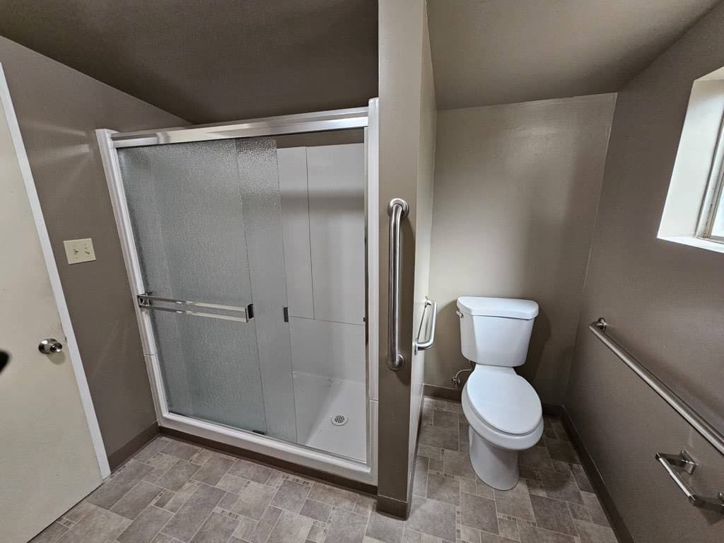 Finished accessible bathroom with a tiled walk-in shower and grab bars by RLS Custom Carpentry in Mendocino County, CA